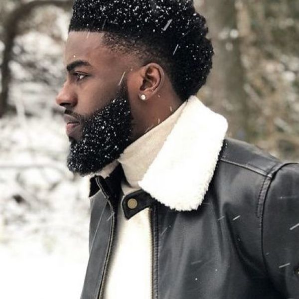 Surinaamse man met afro haar in de sneeuw